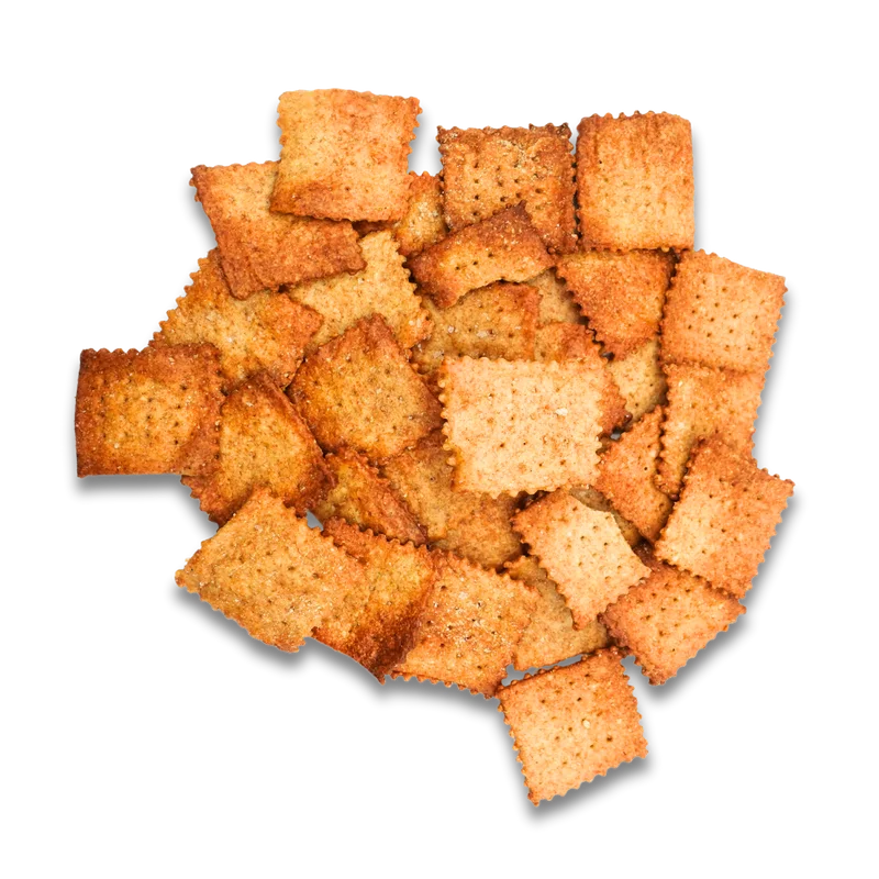 A scattered pile of golden Maake sourdough crackers on white